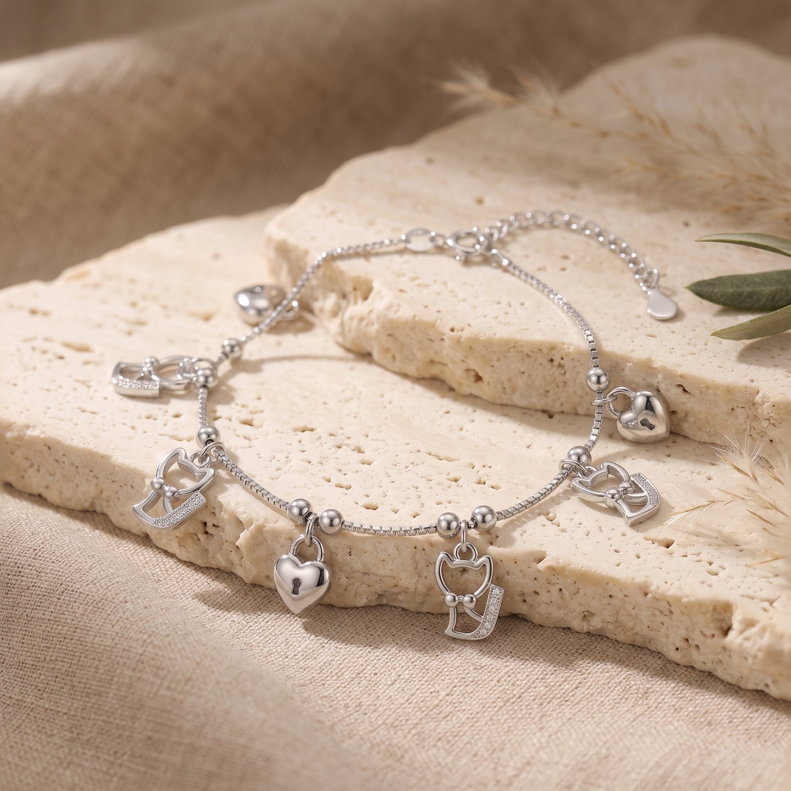 Detailed silver charms arranged on warm stone